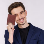 VOZIK card wallet lifestyle view of cross line brown leather wallet for men holding a wallet in hand