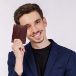 Brown Leather Bifold Wallet - Lifestyle shot of a man holding the wallet in his hand.